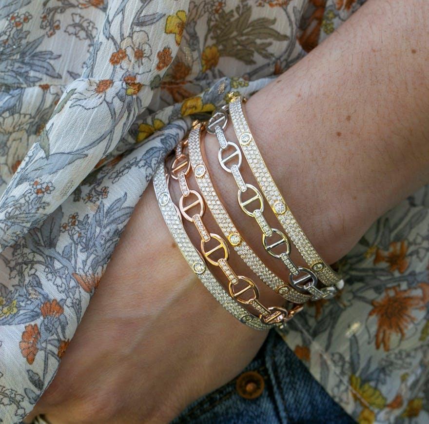 stack of gold and rose gold bracelets with diamonds from lee michaels