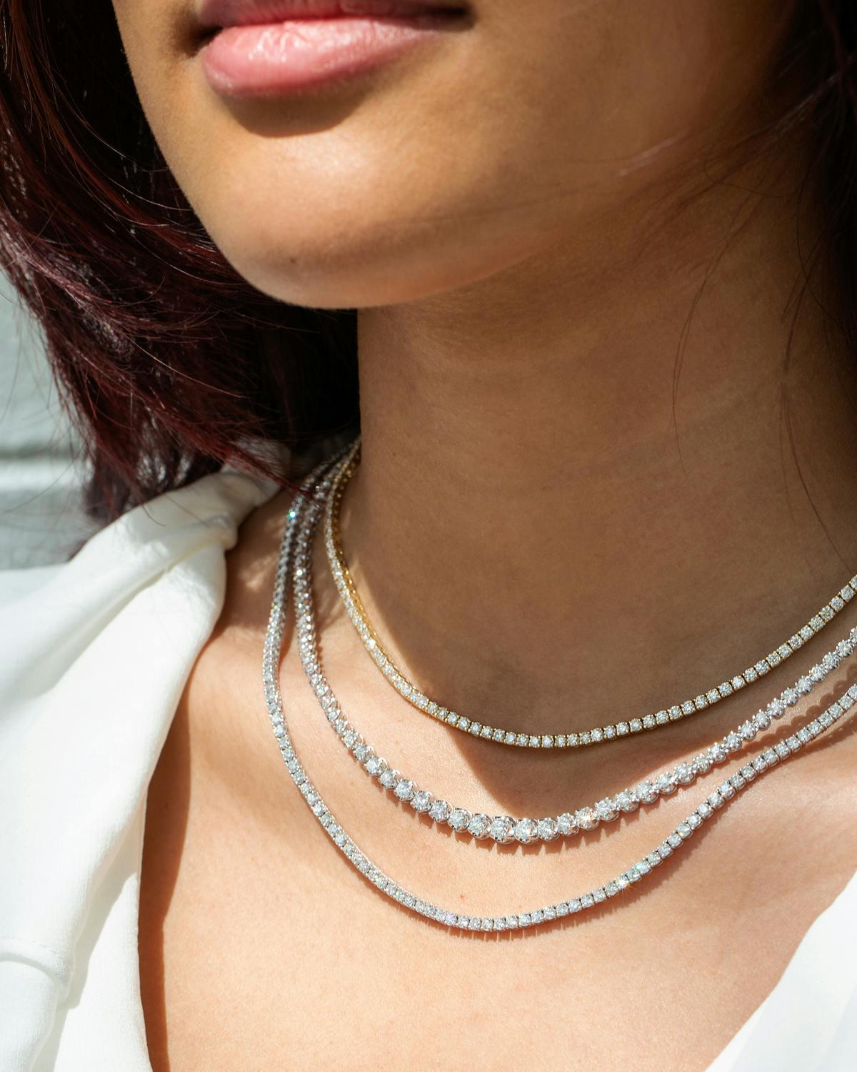 Three diamond necklaces on a woman's neck