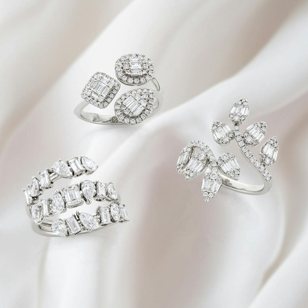 three diamonds rings against a white fabric background
