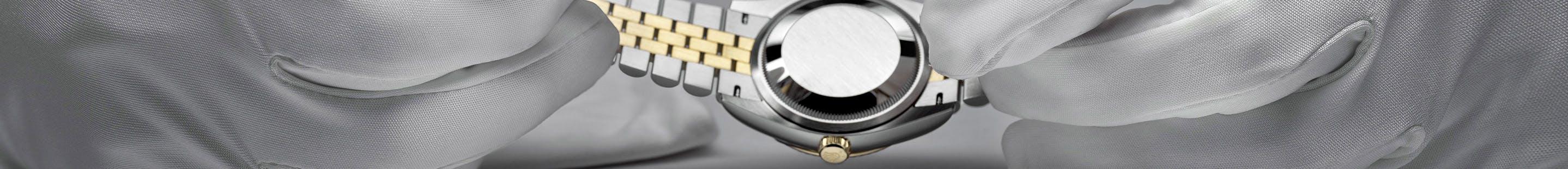 Rolex watch in gloved hands