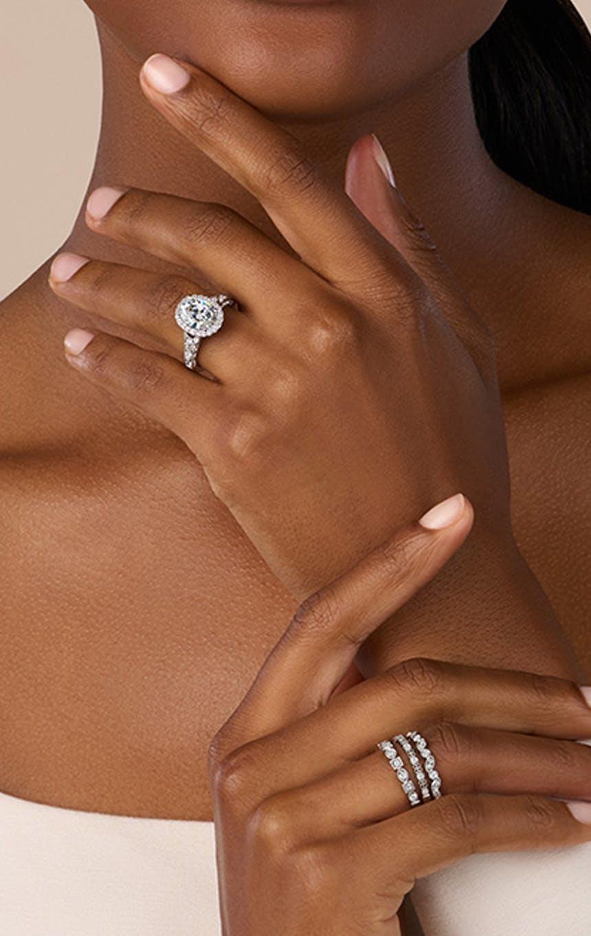 Photo of a woman wearing an engagement ring and wedding bands