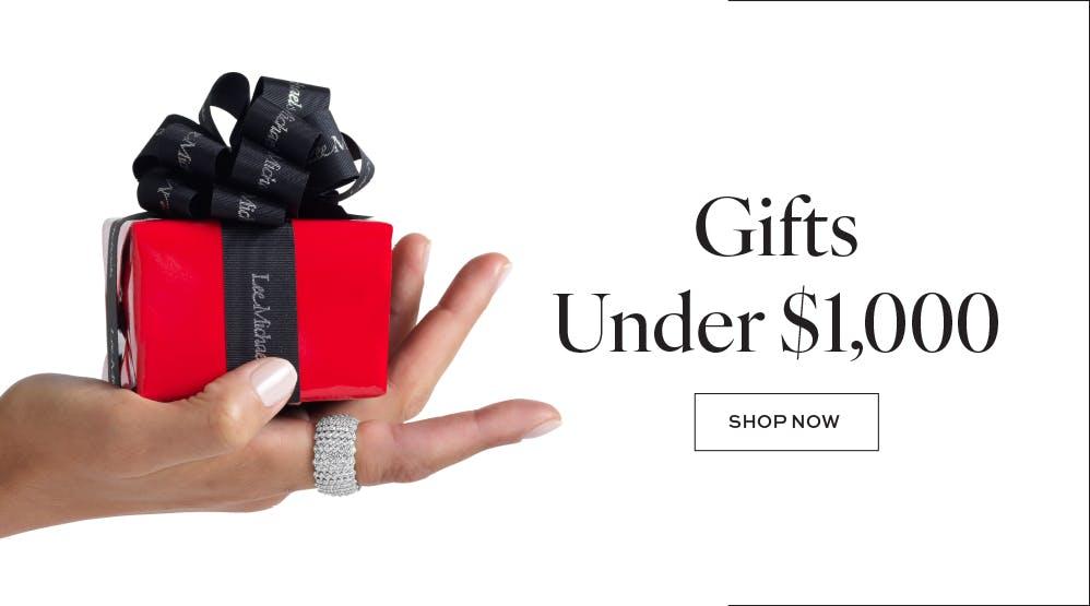 womans hand holding a red Lee Michaels gift wrapped jewelry box and wearing a diamond ring next to the words Gifts under $1000 shop now