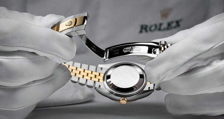 Rolex watch in gloved hands